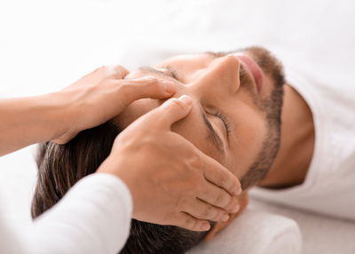 man receiving a facial massage with relaxing hands promoting wellness and six essential techniques